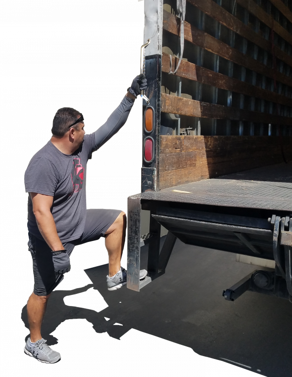 Worker gripping on grab handle installed on back of semi truck